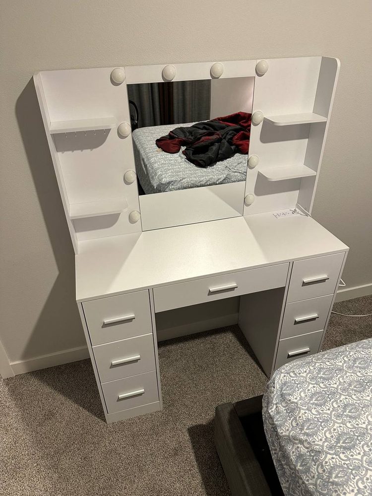 White vanity desk with lighted mirror assembled in a bedroom