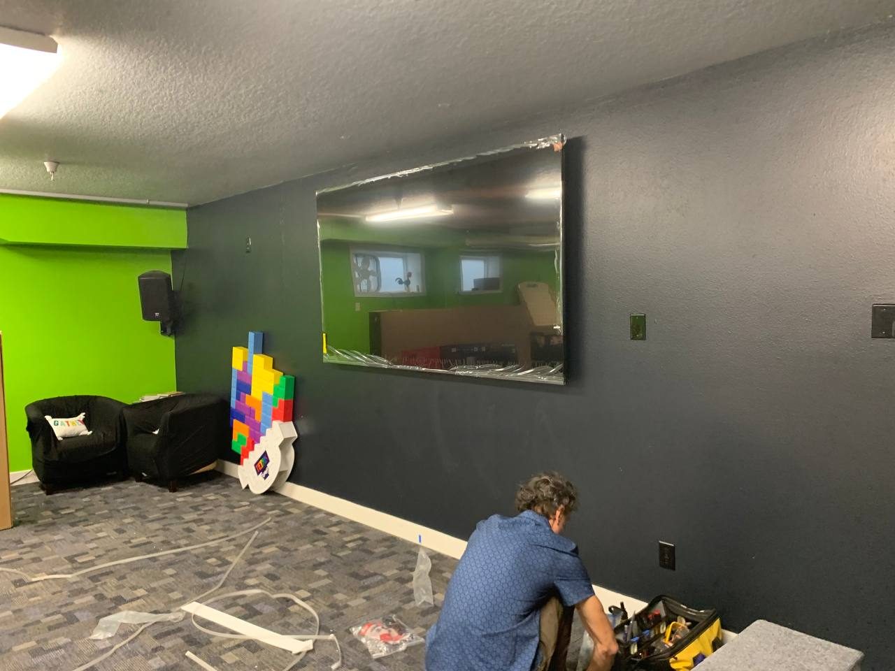 Living room wall repainted with the floor covered and trim protected